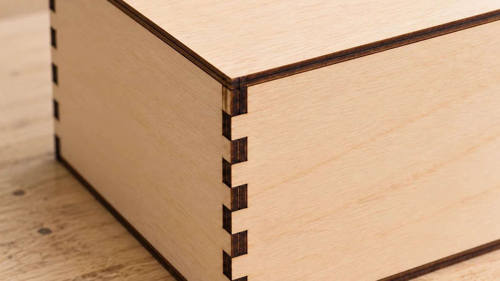 Close view of the birch plywood box corner showing alternating fingers seated flush with the adjacent panel