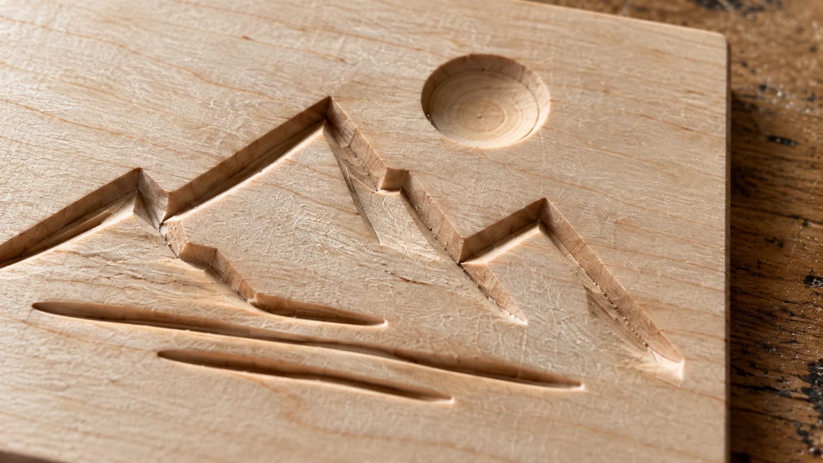 Recessed mountain grooves and a sun pocket in the same maple plaque