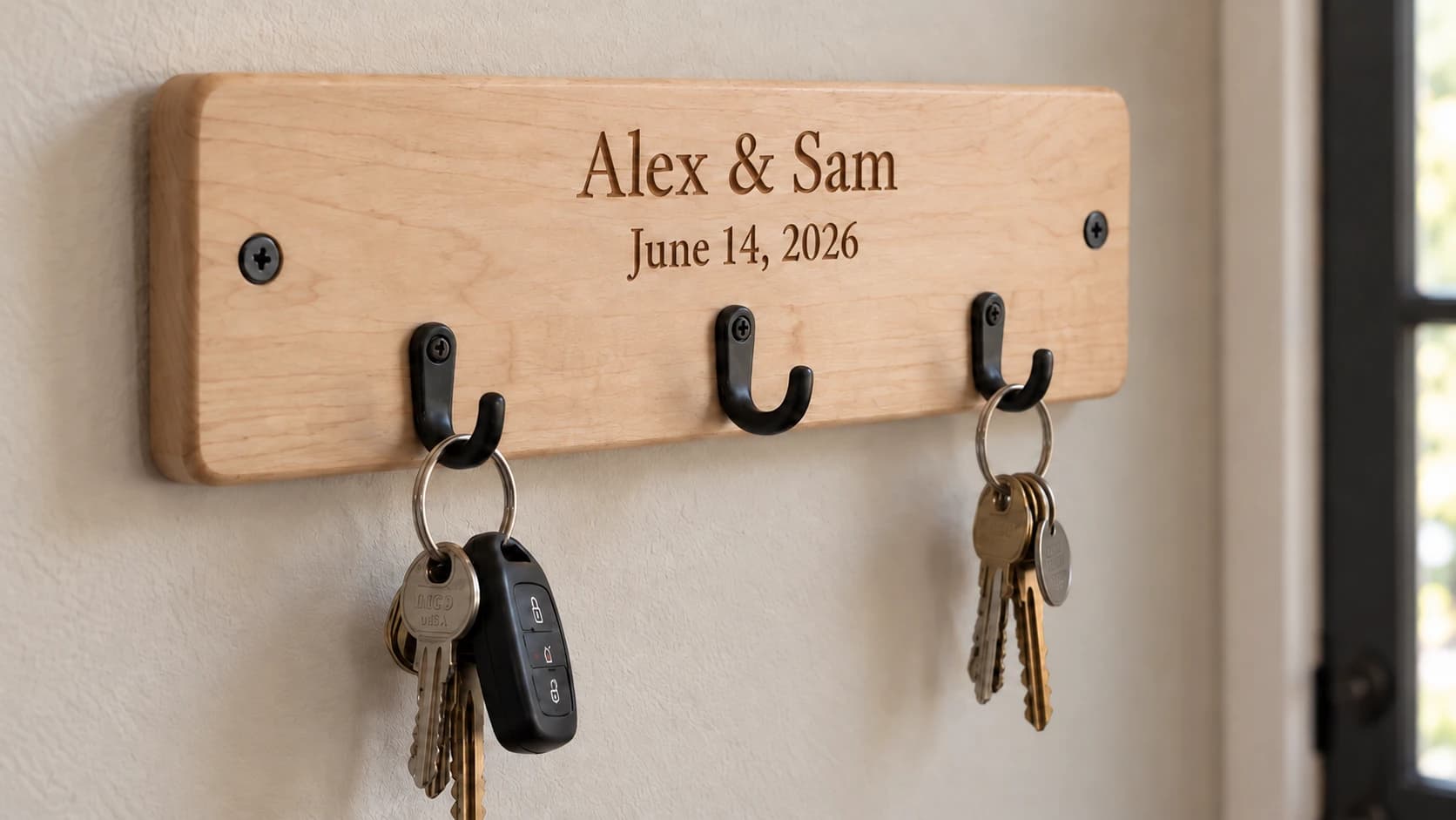 Close-up of Alex and Sam’s engraved maple key rack with screwed metal hooks